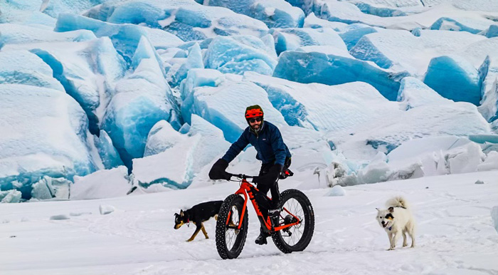 Thomas Flynn cycling with his dogs in the snow