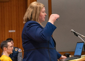 Palmer DA Trina Sears motions with her hand while questioning a witness during the sentencing hearing for Benjamin Wilkins who is in the background dressed in yellow.